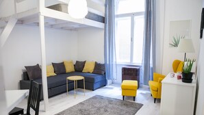 A modern living room with a sofa, yellow chairs, a small table, and a grey rug.