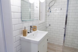 Departamento urbano, 2 habitaciones | Baño | Regadera, toallas, jabón, shampoo 