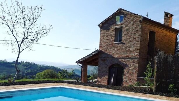 Un edificio de piedra con piscina.