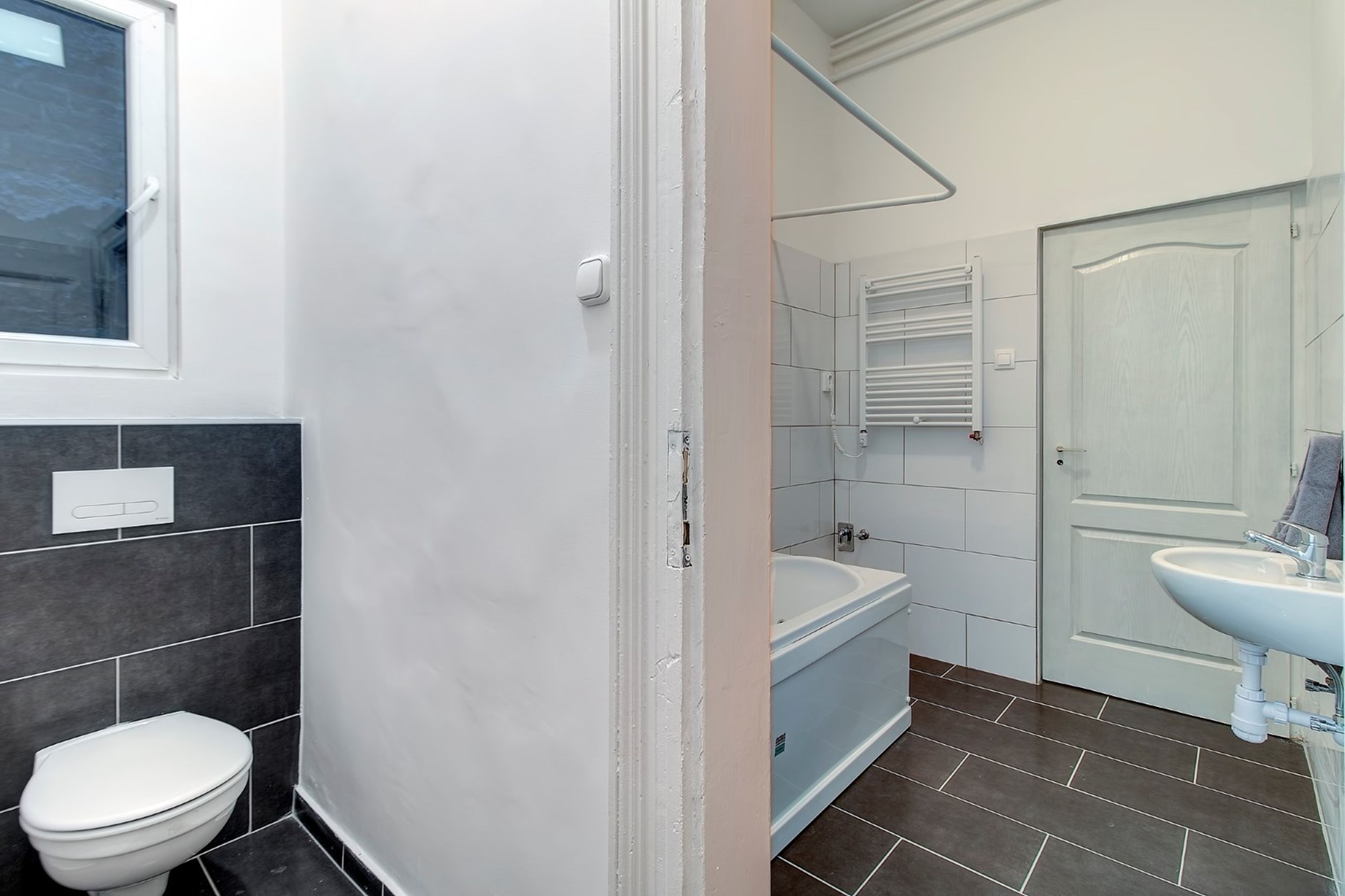 A bathroom with a toilet, bathtub, and sink.
