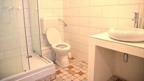 A bathroom with a glass-enclosed shower, a toilet, and a sink. - Incredible Ernesto II (Budapest)