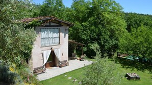A rustic stone building with a balcony, surrounded by lush greenery and a stone pathway leading to the entrance. - A'Loro B&B (Terranuova Bracciolini)