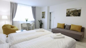 Een hotelkamer met twee bedden, een bank, een bureau en een stoel.