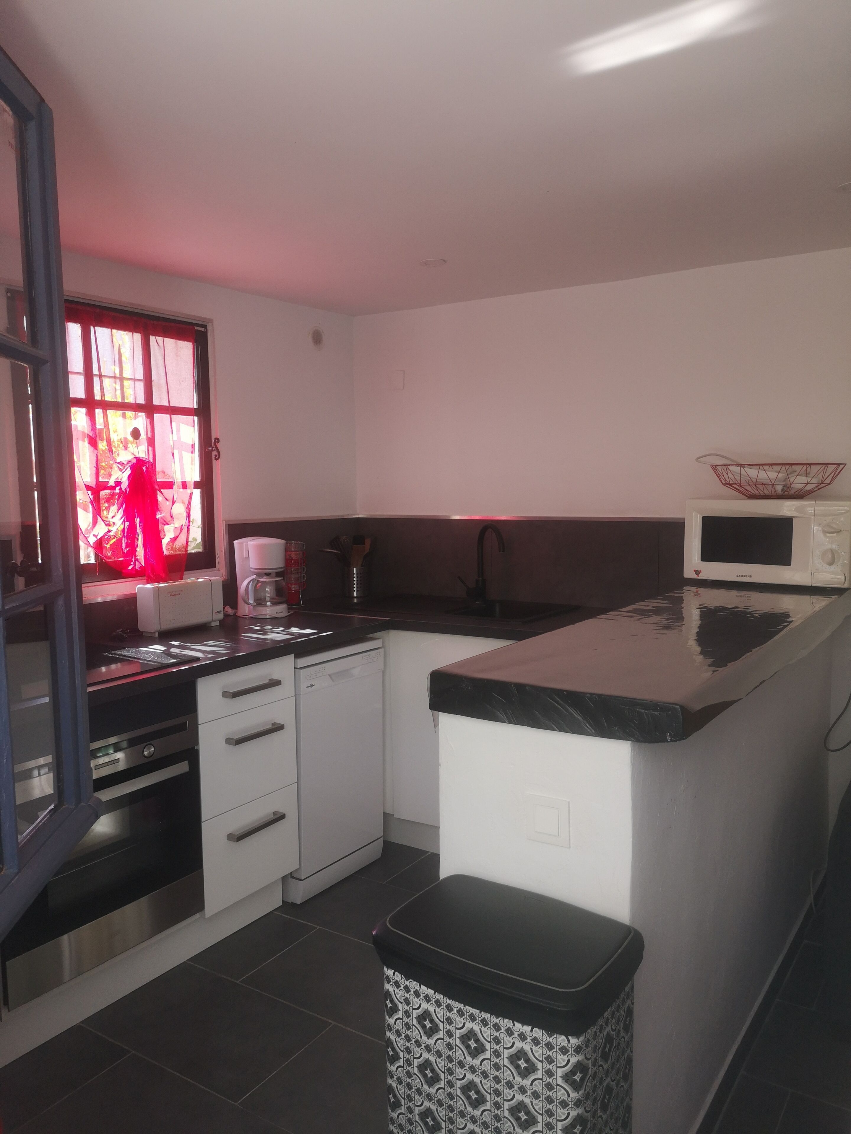 A compact kitchen with a microwave, a coffee maker, and a sink.