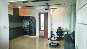 A compact living space with a kitchenette, a dining area, and a bedroom. - Summer 's Homestay (Seri Kembangan)