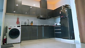 A modern kitchen with a built-in washer, stainless steel appliances, and a large refrigerator. - Summer 's Homestay (Seri Kembangan)