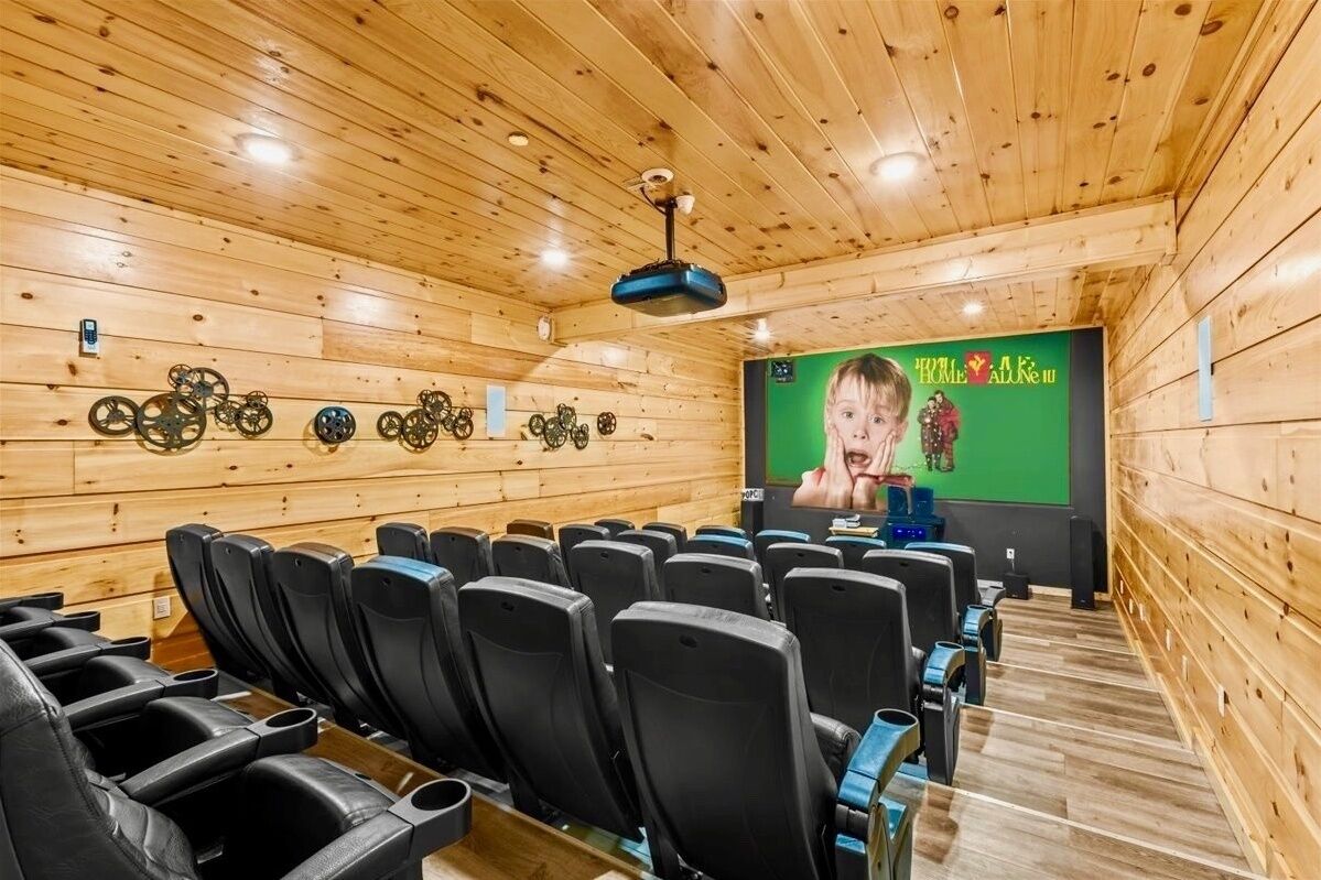 Eine Holzhütte mit einem Kinozimmer, das schwarze Sitze und einen grünen Bildschirm hat.