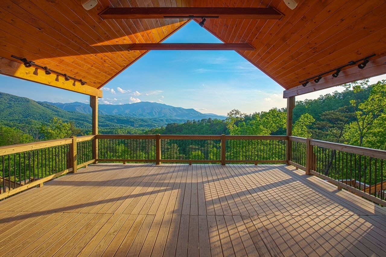 Une terrasse en bois offrant une vue dégagée sur un paysage montagneux.