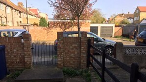 A residential area with a gated entrance, brick walls, and parked cars. - Le Buffle Noir Londres (London)