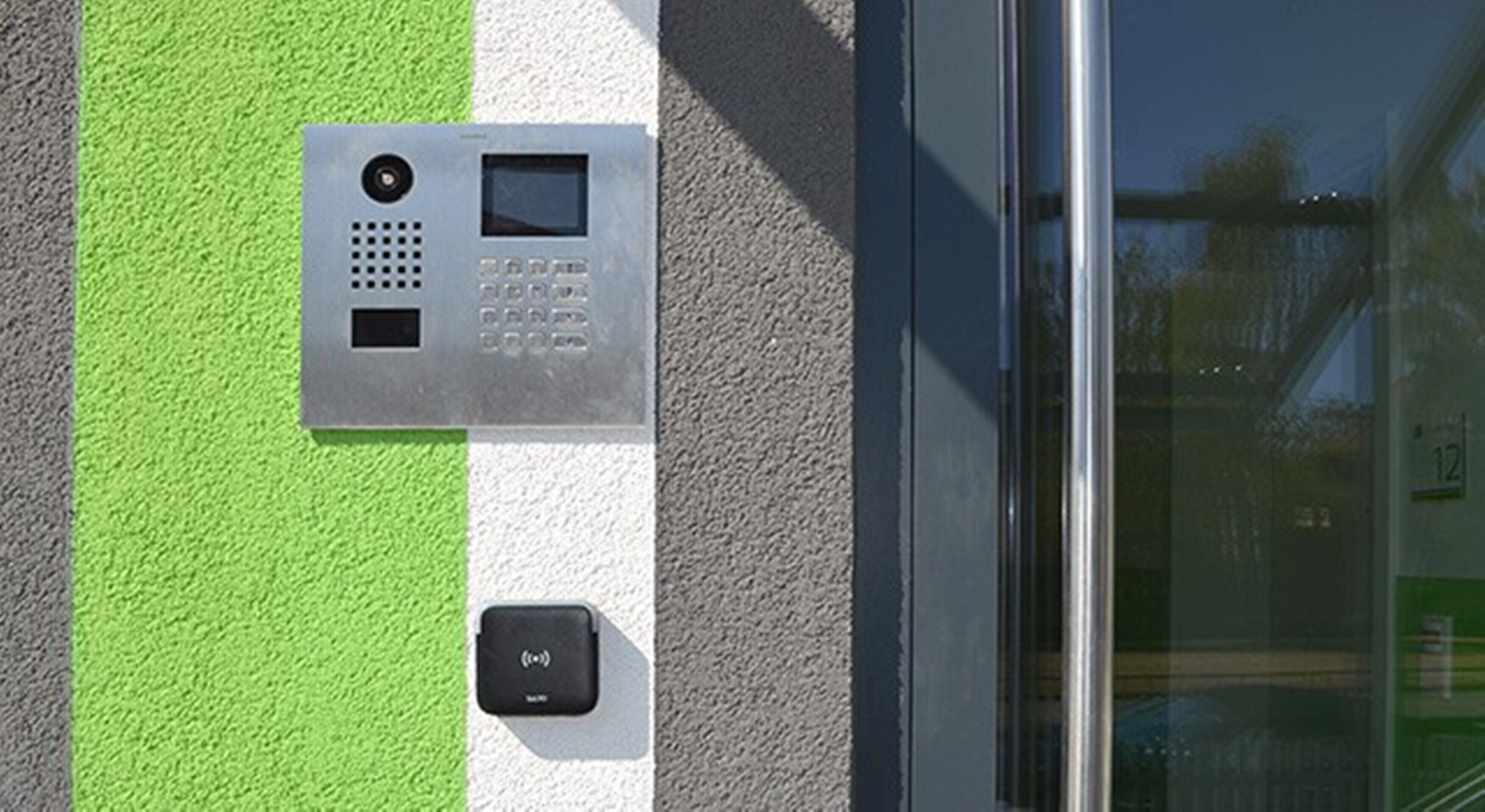 Un clavier de sécurité fixé au mur, avec une bande verte et blanche.