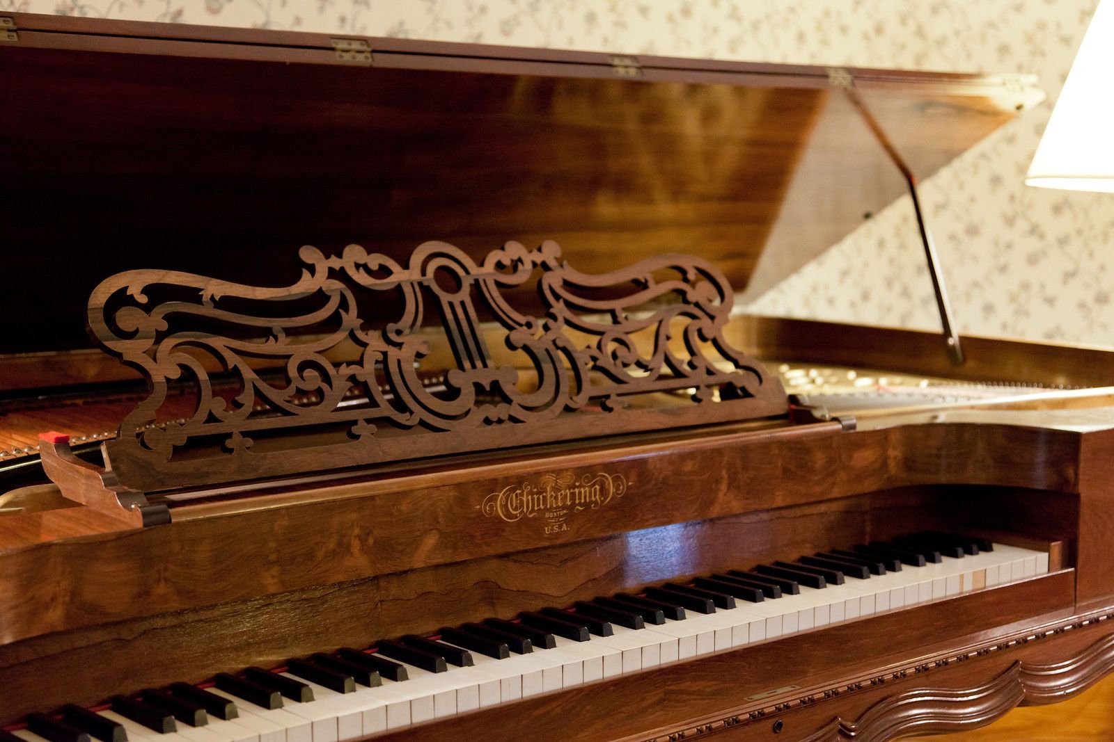 Un piano à queue avec un placage en bois et un pupitre décoratif.