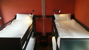 A room with two bunk beds, each with a pillow and a lamp. - O Albergue - Hostel (Lugo)