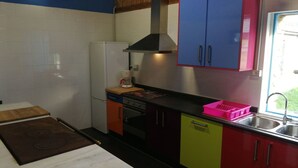 A compact kitchen with a stove, oven, and sink. - O Albergue - Hostel (Lugo)