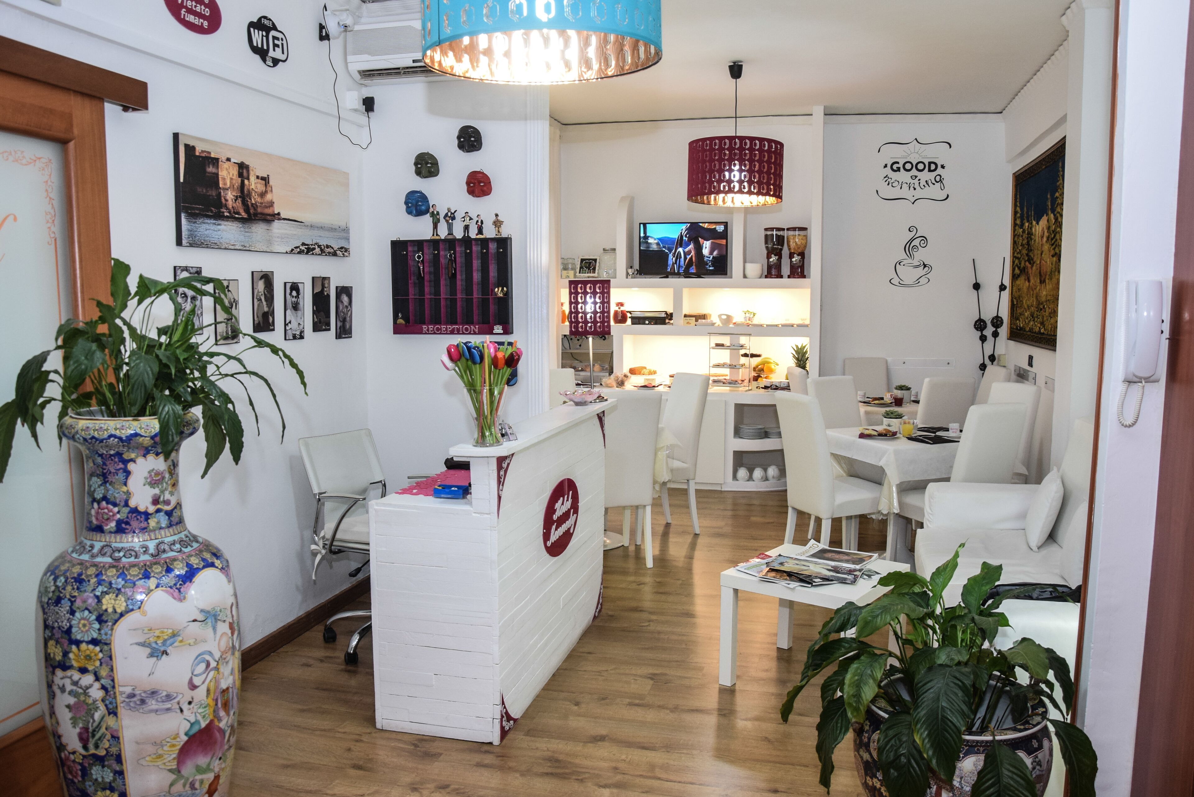 A modern interior with a reception desk, white furniture, a large vase, and wall decorations.