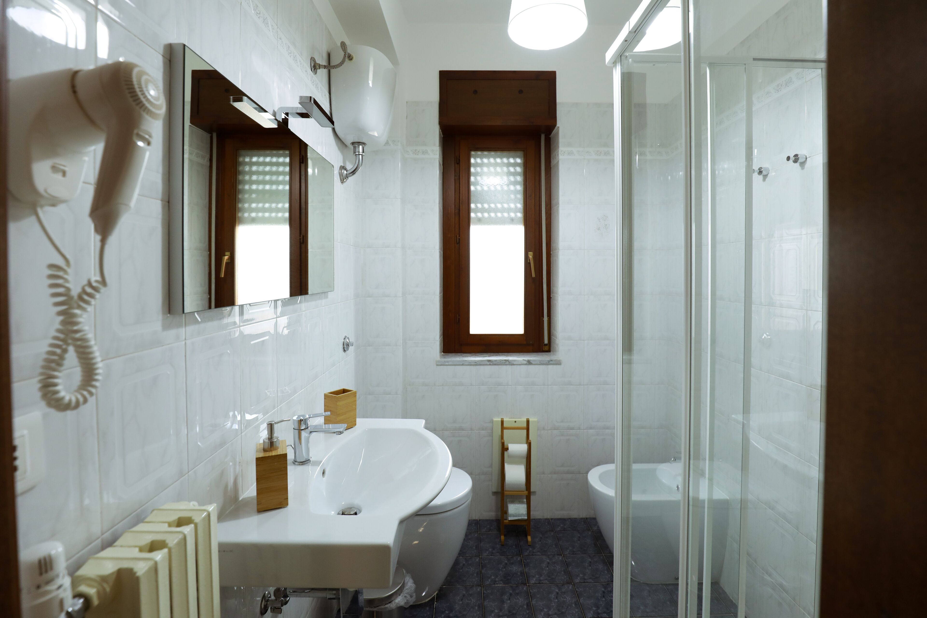 Un baño con bañera, inodoro y cabina de ducha de vidrio.