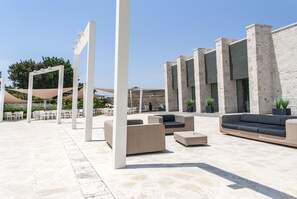 Un espace extérieur aménagé avec des meubles en osier et un sol en pierre.