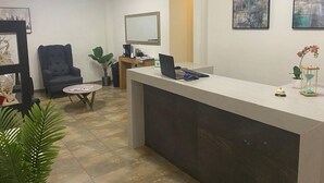 A reception area with a desk, chair, and potted plants. - Hotel 15 Avenida (Tapachula)