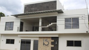 A modern two-story building with a balcony, a staircase, and a sign indicating the address as 15 Avenida. - Hotel 15 Avenida (Tapachula)