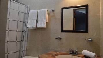 A bathroom with a shower, toilet, and sink.