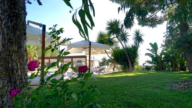 A garden area with a white gazebo, lounge chairs, and a tree. - B&B il giardino di Agata (Mascalucia)