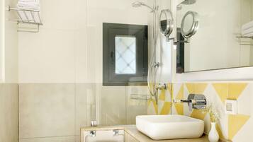 Un bagno moderno con uno specchio grande, un lavandino bianco e una zona doccia.