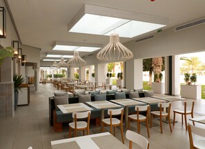 A spacious dining area with high ceilings, modern pendant lighting, and a view of the outdoors. - The Mirage Resort & SPA (Hammamet)