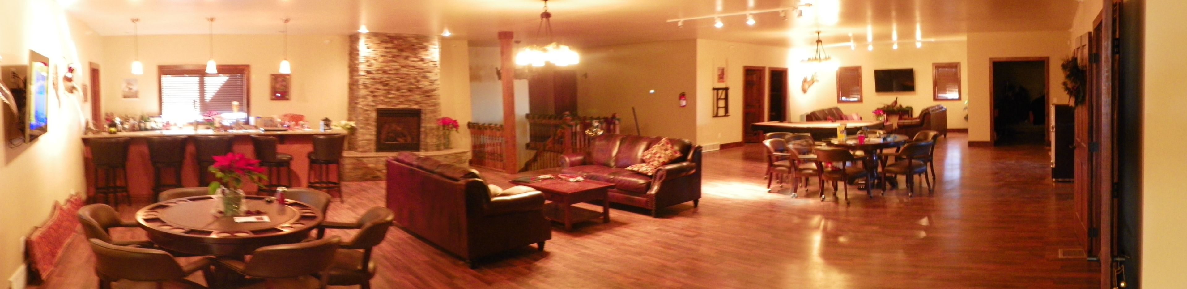 A spacious living room with a fireplace, a dining area, and a kitchen in the background.