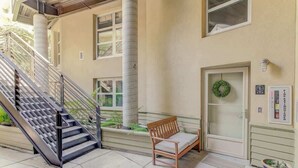 A building entrance with a staircase, a bench, a door with a wreath, and a signboard. - Spacious Luxury Historic Loft in Downtown SF (San Francisco)
