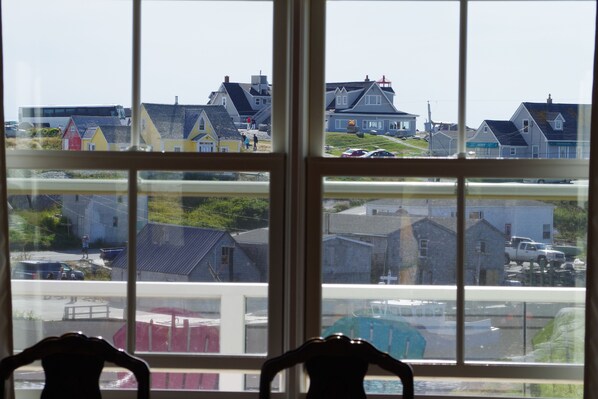 A view through a window with a view of colorful houses and a parking lot.