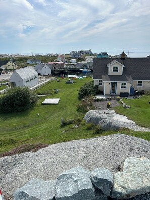 A coastal village with houses, a dock, and a grassy area.