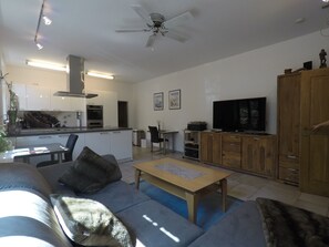 En moderne stue med en sofa, et sofabord og et fjernsyn.