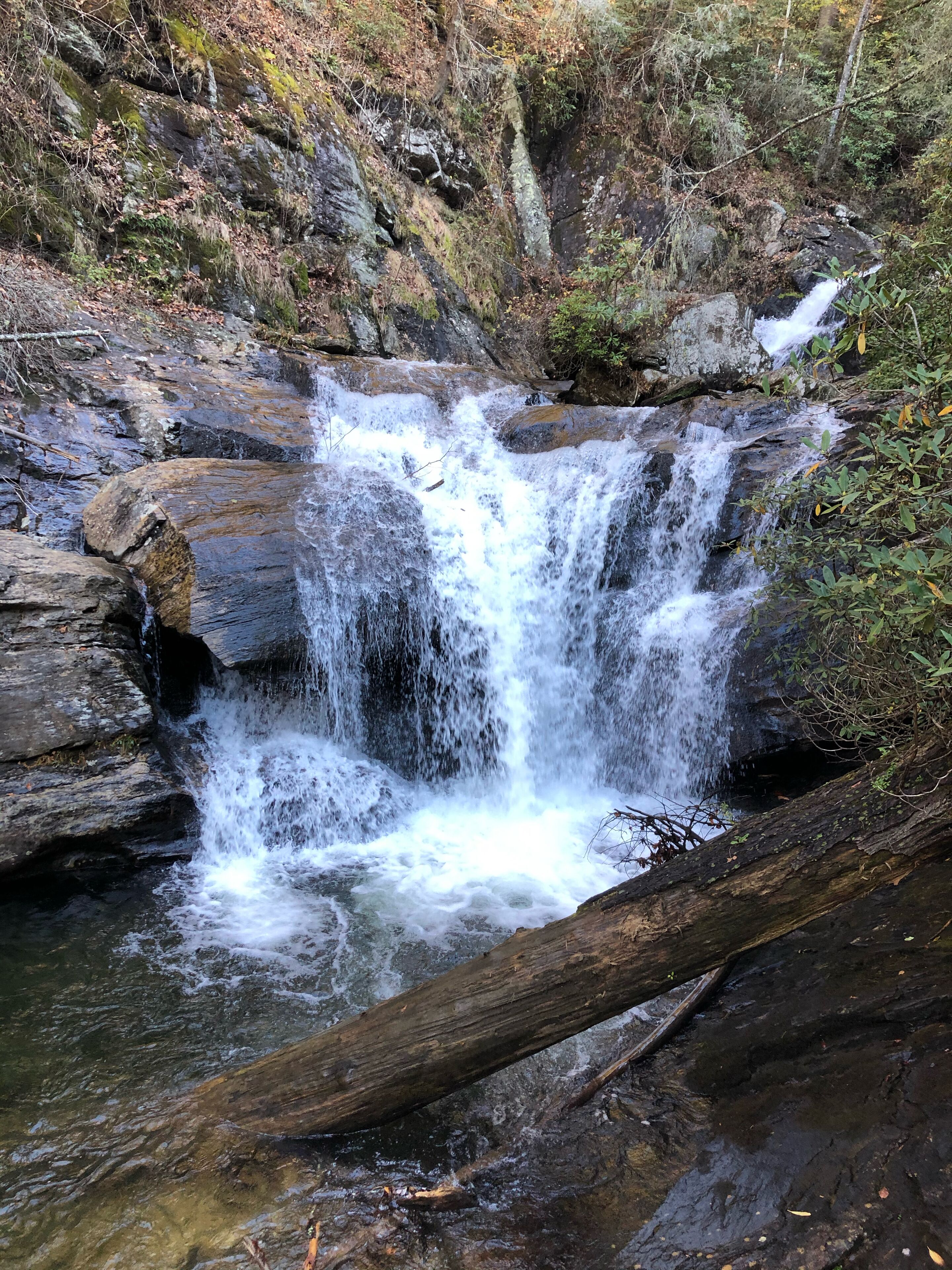 A waterfall cascading over rocks in a forested area.