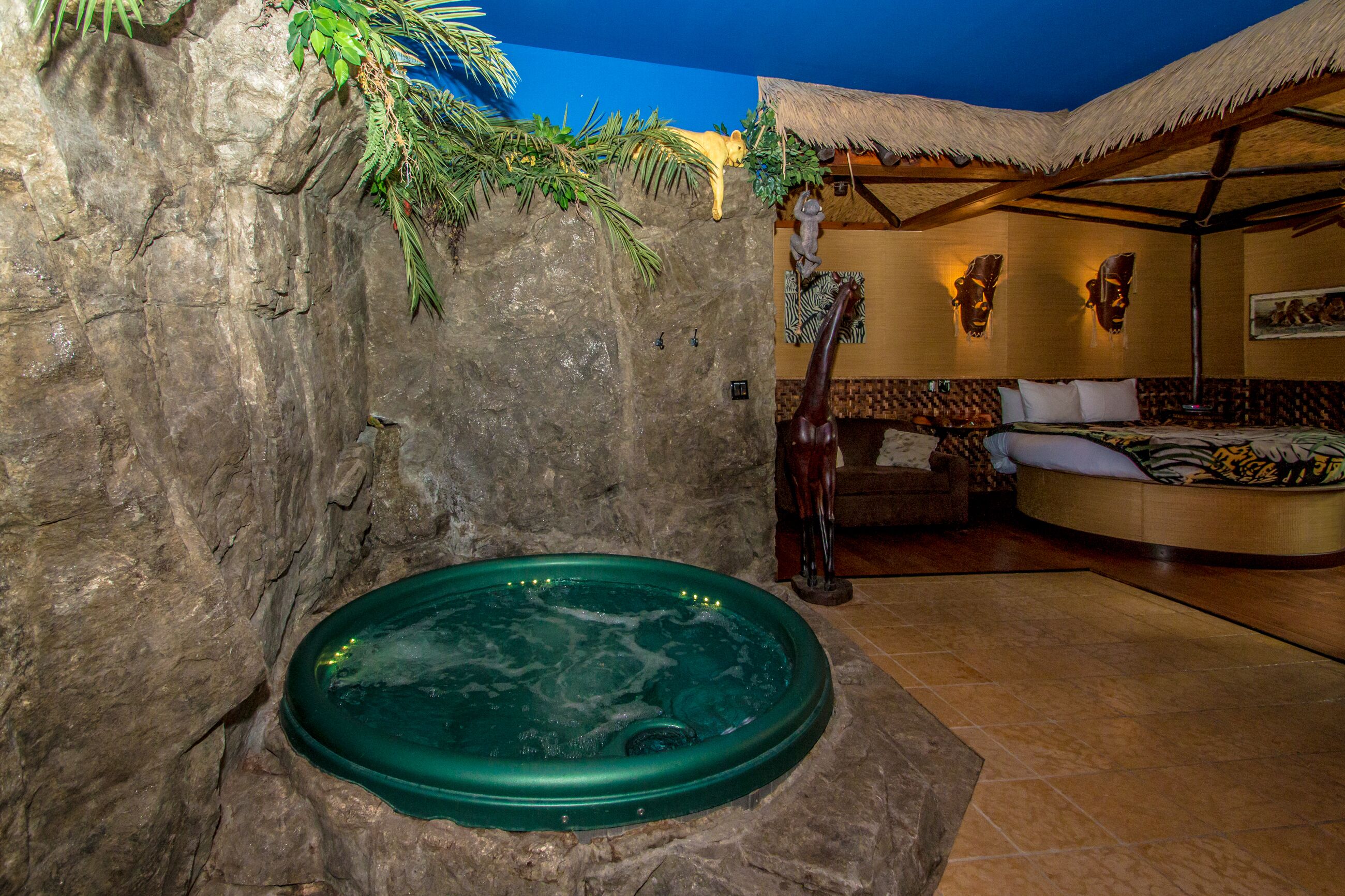 Un espace de détente avec un jacuzzi, un banc en bois et une structure à toit de chaume.