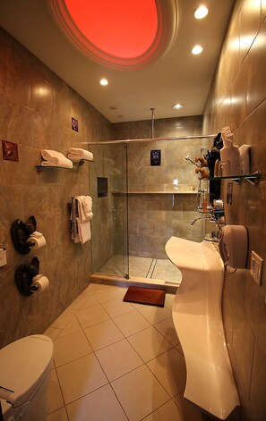 A modern bathroom with a glass-enclosed shower, a white bathtub, and a toilet. - Adventure Suites (North Conway)