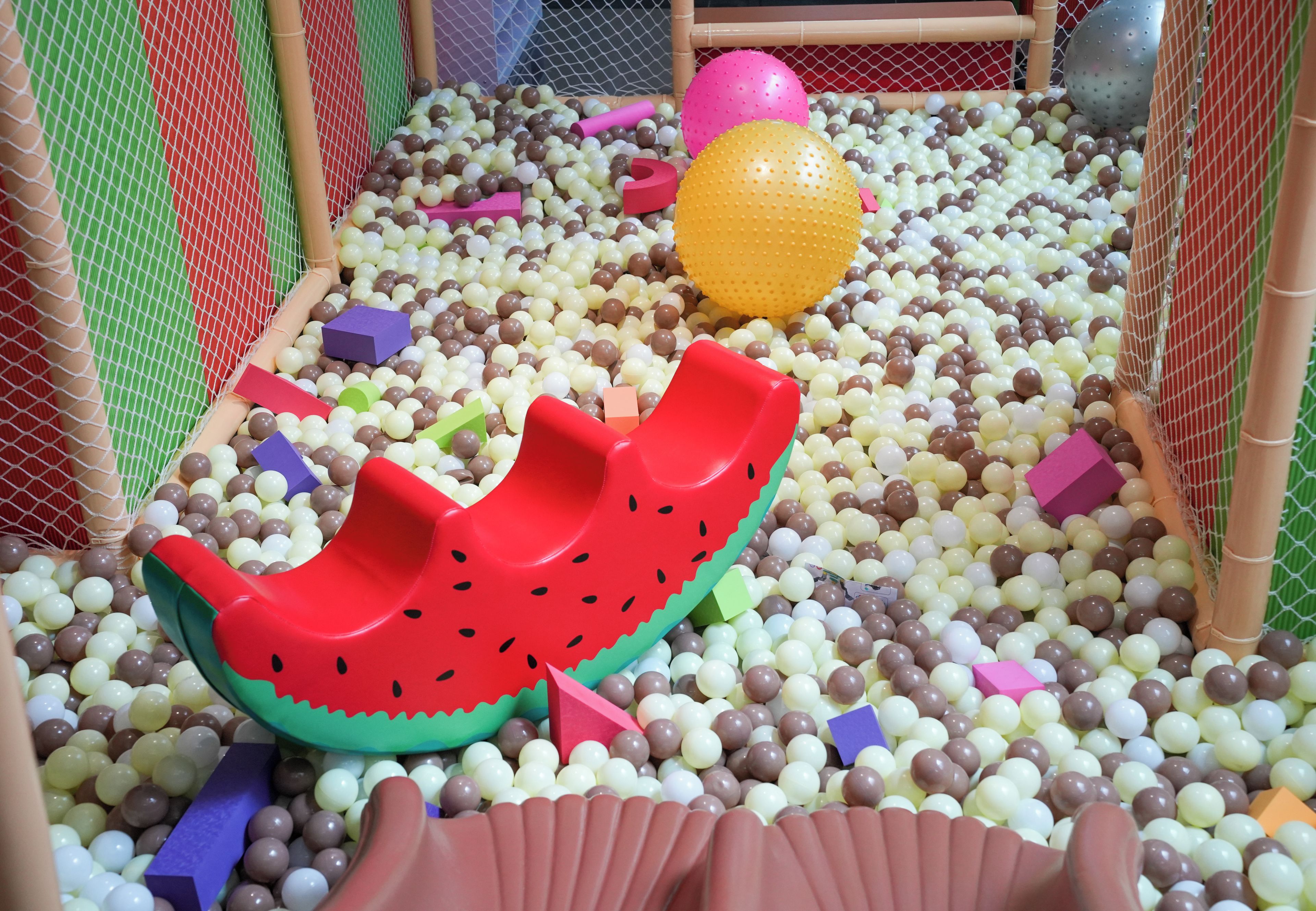 A play area with a slide, balls, and various shapes.