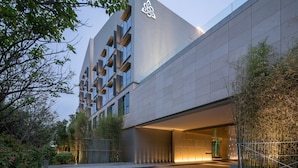 Un edificio moderno con un diseño arquitectónico único, que presenta un logotipo destacado en la fachada.