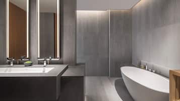 A modern bathroom with a large rectangular sink, a freestanding bathtub, and a mirror above the sink.