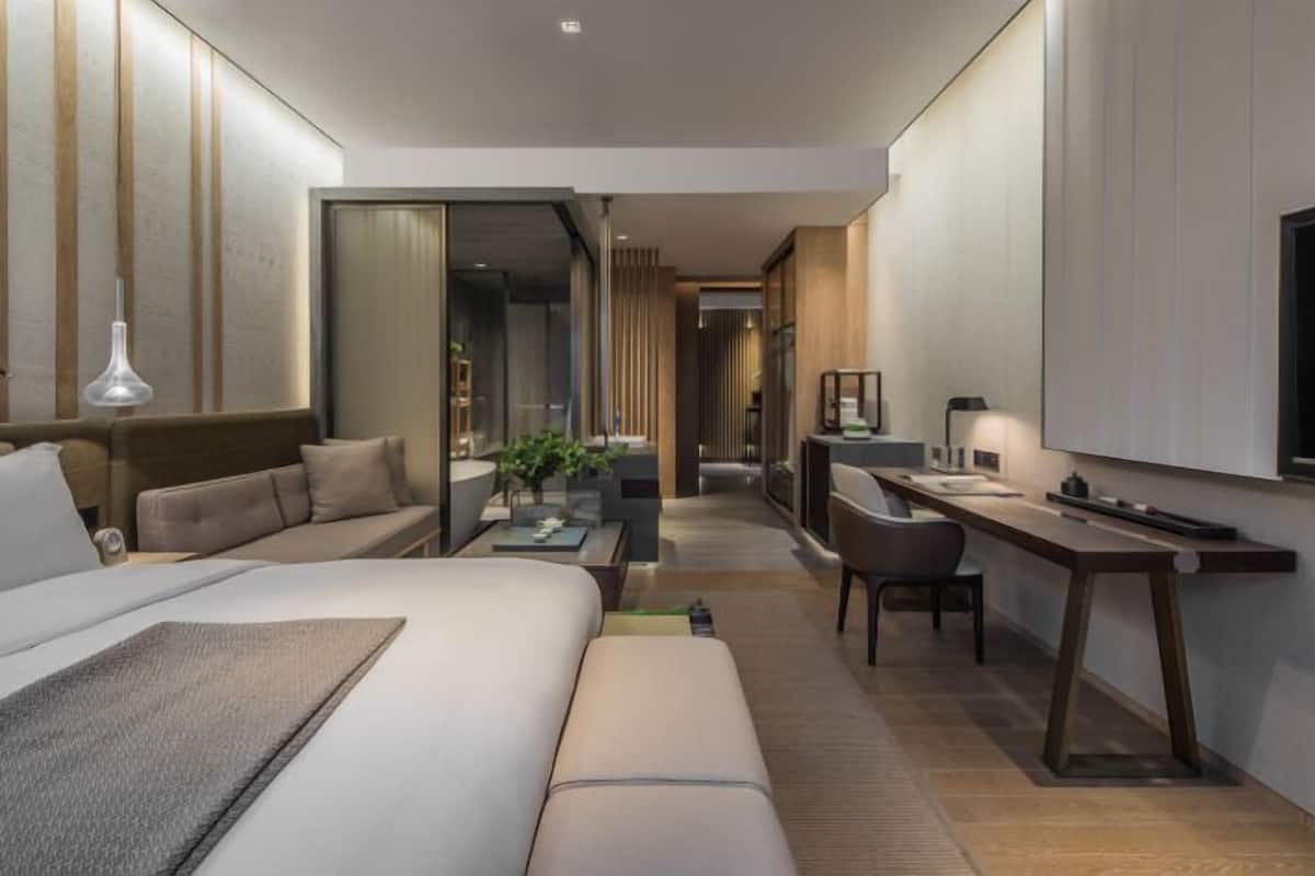 Une chambre d’hôtel moderne équipée d’un lit, d’un canapé, d’un bureau et d’une télévision.