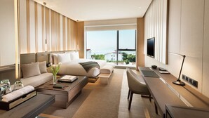 Une chambre d’hôtel moderne, dotée d’un grand lit, d’un canapé, d’un bureau et d’une télévision.