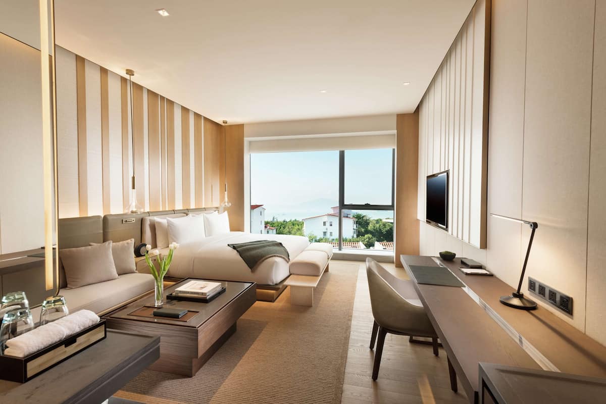 Une chambre d’hôtel moderne, dotée d’un grand lit, d’un canapé, d’un bureau et d’une télévision.