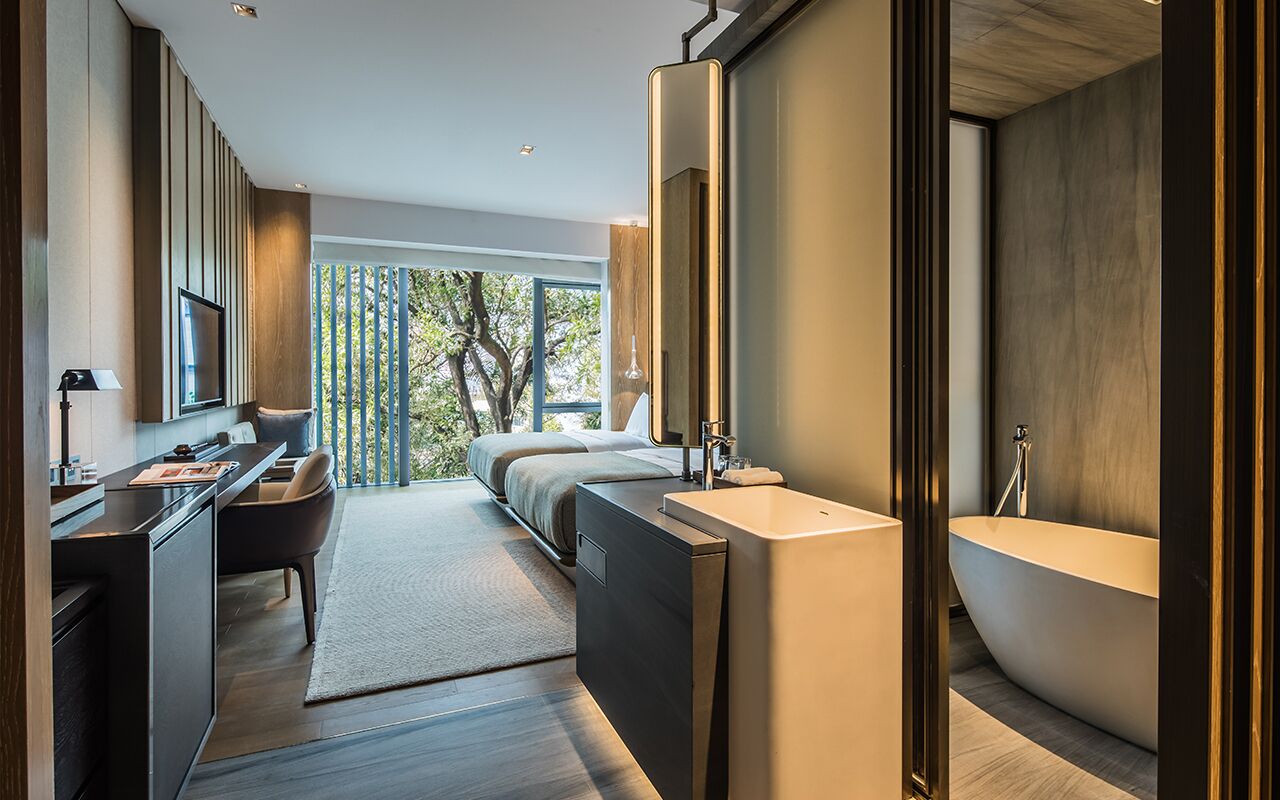 A modern bathroom with a freestanding bathtub, a large mirror, and a sleek vanity.
