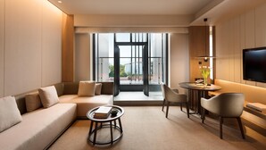 Un salon moderne avec un canapé, une table basse, un téléviseur et une vue sur le balcon.