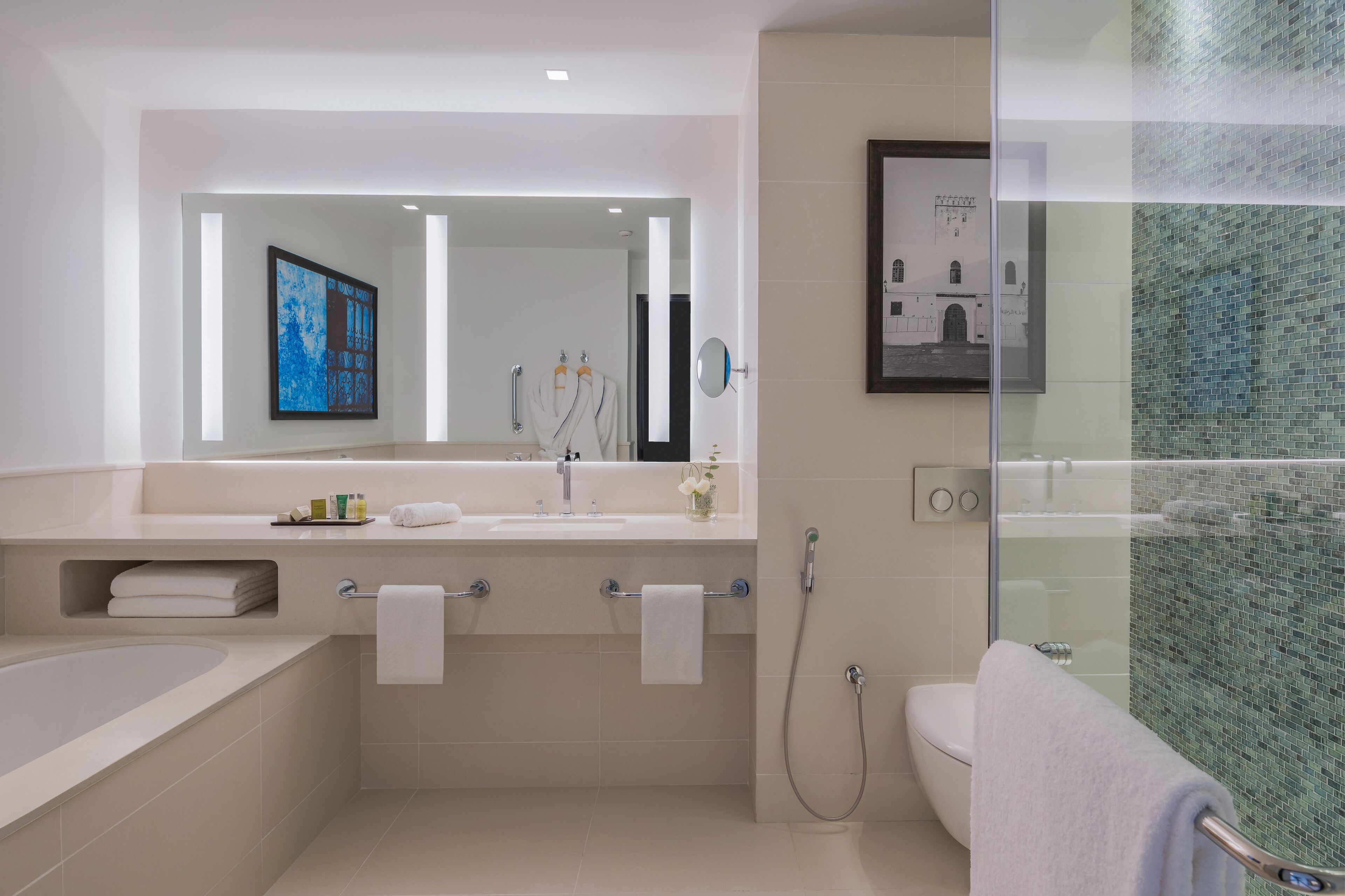 Une salle de bain moderne avec une baignoire, un lavabo avec un miroir et un espace douche.
