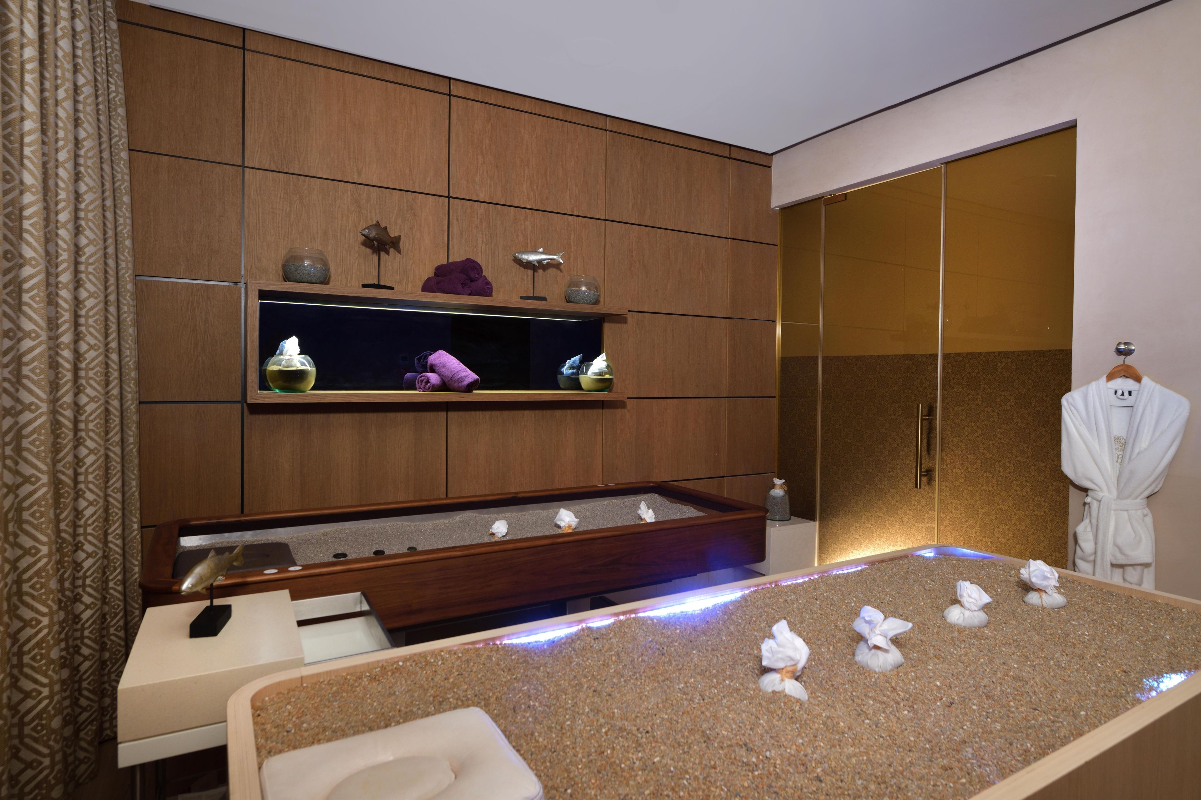 Une salle de bain moderne avec un meuble-lavabo en bois, une grande baignoire agrémentée de serviettes et un peignoir suspendu à un porte-peignoir.