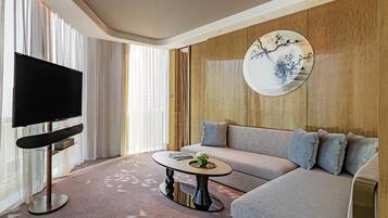 Suite Deluxe, 1 cama King size | Área de sala de estar | Televisión de 55 pulgadas con canales por cable