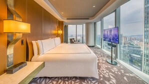 A modern hotel room with a large bed, a TV, and a city view. - Conrad Hangzhou (Hangzhou)