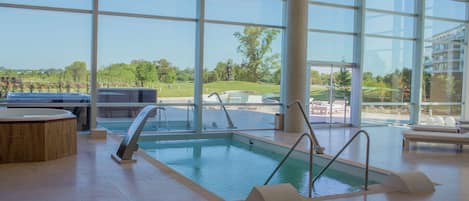 Una piscina cubierta, una piscina al aire libre de temporada, sombrillas