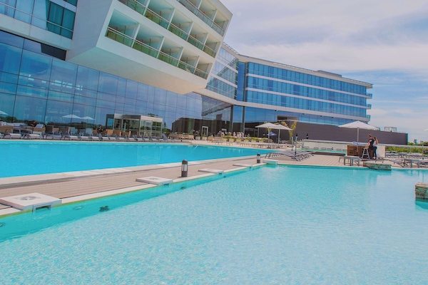 Una piscina cubierta, una piscina al aire libre de temporada, sombrillas