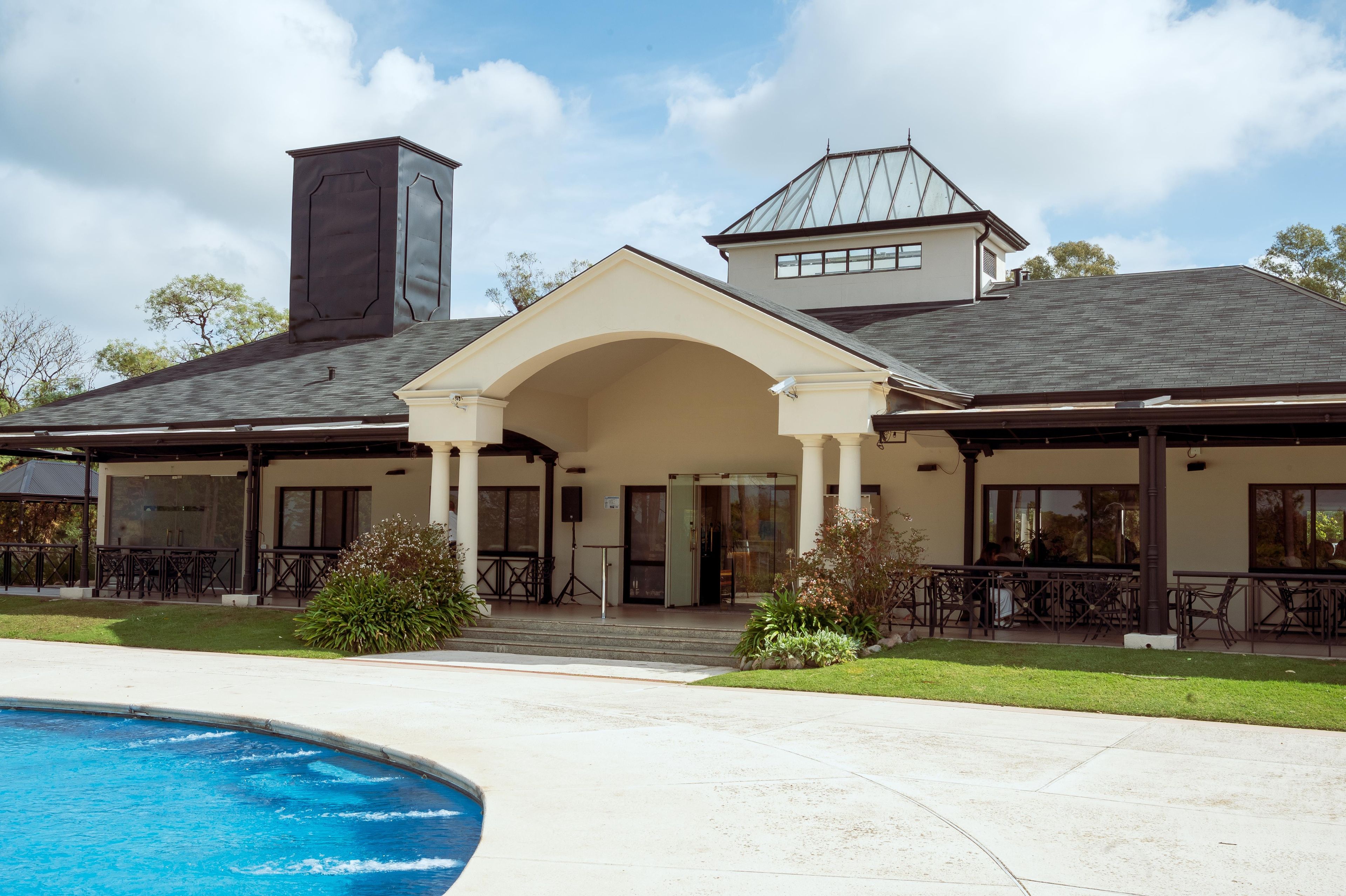 A two-story building with a covered patio area and a swimming pool.