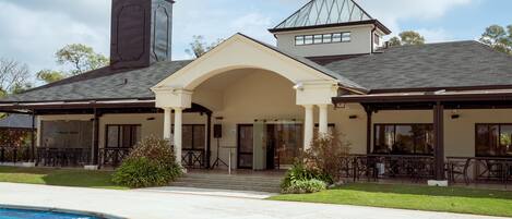 A two-story building with a covered patio area and a swimming pool.